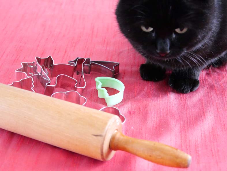 Katze und Keksausstecher beim Plätchenbacken