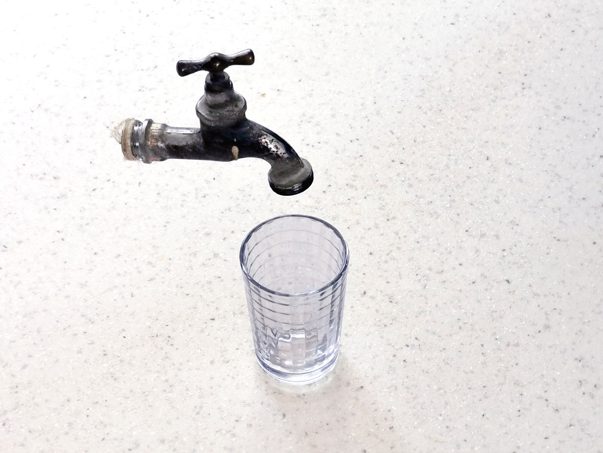 Wasserhahn mit leerem Glas